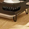 A close-up view of a black kitchen sink caddy with a white sponge and a metal scrub pad, resting on a wooden surface. Voir les images du produit
