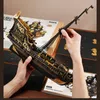 A person is assembling a wooden model ship, with the box and instructions visible in the background. Náhled obrázku produktu
