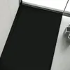 A black shower tray with a drain cover in a modern bathroom setting. Produktbild-Vorschau