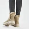 A person wearing beige winter boots and grey jeans, shown from the back. Voir les images du produit
