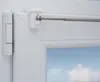 Close-up of a white window frame with a silver telescopic curtain rod attached. Produktbild-Vorschau