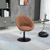 A brown tufted swivel armchair with a black base is placed on a light blue and gray rug in a modern living room setting. Produktbild-Vorschau