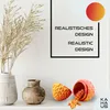 A decorative shelf display featuring dried grass in a vase, two ceramic vases, and a 3D printed dragon egg that has opened to reveal a dragon figurine. A framed text graphic is on the wall behind. Produktbild-Vorschau