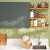 A kitchen scene with cabinets, shelves of jars, a sink, and a dish rack. Anteprima dell’immagine prodotto