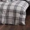 A close-up view of a plaid duvet cover on a bed. Produktbild-Vorschau
