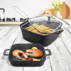 A kitchen scene with two cooking pans on a wooden table. One pan is a grill pan with salmon, and the other is a deep fryer with french fries. Anteprima dell’immagine prodotto