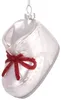 A white glass baby shoe ornament with a red glitter bow. Voir les images du produit