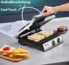 A hand is shown closing a sandwich maker with two sandwiches inside. A cup of coffee and a book are on the counter. Anteprima dell’immagine prodotto