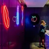 A woman applying makeup in a bathroom with neon lights. Produktbild-Vorschau