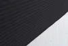 A close-up view of a black cord fabric and a white quilted mattress. Voir les images du produit