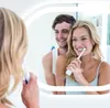 A couple brushing their teeth in front of a mirror with LED lighting. Podgląd zdjęcia produktu