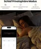A woman sleeping in bed, with a smartphone displaying a security camera app in the foreground. Produktbild-Vorschau