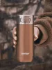A hand holding a copper-colored Contigo travel mug. Produktbild-Vorschau
