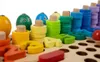 A close-up view of a wooden educational toy with colorful stacking rings and number shapes. Produktbild-Vorschau