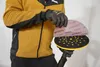 A person wearing gloves is holding a sanding pad over a sanding disc. Podgląd zdjęcia produktu