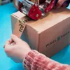Hands taping a cardboard box with eco-friendly tape. Produktbild-Vorschau
