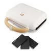 A white sandwich maker with a wooden handle and three interchangeable plates shown below it. Podgląd zdjęcia produktu