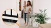 A woman is holding a baby and walking through a doorway with a baby gate installed. Anteprima dell’immagine prodotto