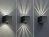 Three different wall lights are shown, each casting unique light patterns on a gray wall. Produktbild-Vorschau