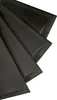 A close-up, angled view of several black, textured ceiling or wall panels stacked on top of each other against a white background. Produktbild-Vorschau