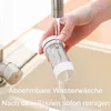 A hand is rinsing a filter component under a faucet in a sink. Produktbild-Vorschau