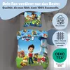 A Paw Patrol themed bedding set displayed on a bed, with promotional text and certification icons. Produktbild-Vorschau