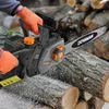 A person wearing orange gloves is using a DOVAMAN electric chainsaw to cut a log. Produktbild-Vorschau