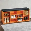 An orange shoe cabinet with a black seat cushion on top, filled with various shoes and a handbag. Produktbild-Vorschau