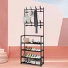 A metal coat rack and shoe rack with various items displayed on it, set against a pink and white background. Náhled obrázku produktu