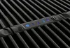 A close-up view of a black grill with a control panel showing numbers and illuminated buttons. Produktbild-Vorschau