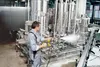 A man is cleaning industrial machinery with a high-pressure washer. Náhled obrázku produktu