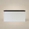 A white shoe cabinet with a black cushion on top, shown from the front against a plain background. Produktbild-Vorschau