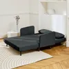 A dark gray sofa bed is shown in a living room setting, with a side table and a vase of dried flowers. Produktbild-Vorschau