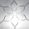 Several clear plastic spoons are arranged in a circular, flower-like pattern against a light gray and white gradient background. Produktbild-Vorschau