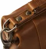 A close-up shot of the hardware and leather details of a brown handbag. Podgląd zdjęcia produktu