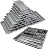 A stack of silver-grey drawer organizers and one organizer filled with cutlery. Produktbild-Vorschau