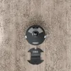 A robot vacuum cleaner and its charging dock are shown from a top-down view on a textured floor. Produktbild-Vorschau