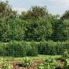 A green wire mesh fence in a garden setting, with plants in the foreground and trees in the background. Produktbild-Vorschau
