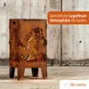 A rusty metal fire pit with a tractor design, placed outdoors against a wooden wall. Produktbild-Vorschau