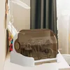 A baby bottle drying rack is shown on a white surface, with a dark curtain in the background. Produktbild-Vorschau