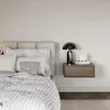 A close-up view of a bed with a nightstand next to it. Produktbild-Vorschau