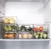 Clear plastic storage containers filled with various food items, neatly arranged on a shelf inside a refrigerator. Náhled obrázku produktu