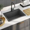 A modern kitchen sink with a black faucet on a white countertop. Voir les images du produit