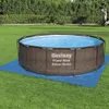 An above-ground swimming pool set up on a grassy lawn, with a blue tarp underneath. Produktbild-Vorschau