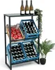 A display stand for beverages and produce, with bottles in blue crates and tomatoes in a wooden crate, topped with three bottles of wine and a plant. Produktbild-Vorschau