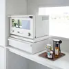 A white kitchen appliance stand with a microwave and a drawer, placed on a white countertop next to a window. Podgląd zdjęcia produktu