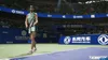 A female tennis player stands on a court in a stadium with spectators in the background. Podgląd zdjęcia produktu