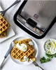 A waffle maker with waffles and a dip on a table. Voir les images du produit