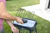 A person is using an electric grill outdoors on a lawn. Náhled obrázku produktu
