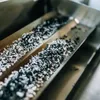 A close-up view of ash in a metal tray, likely from a smoker's product. Produktbild-Vorschau